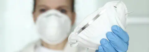 zorgprofessional met mondkapje in hand