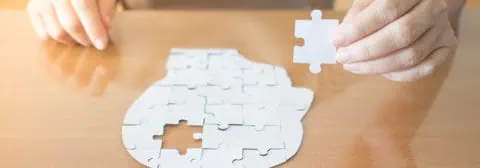 persoon legt papieren puzzelstukje van hersenen