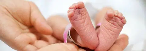 twee babyvoetjes op hand